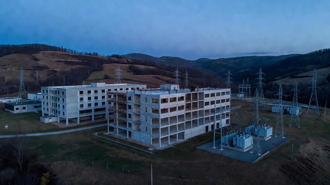 Two concrete buildings, one finished and one an unfinished shell.