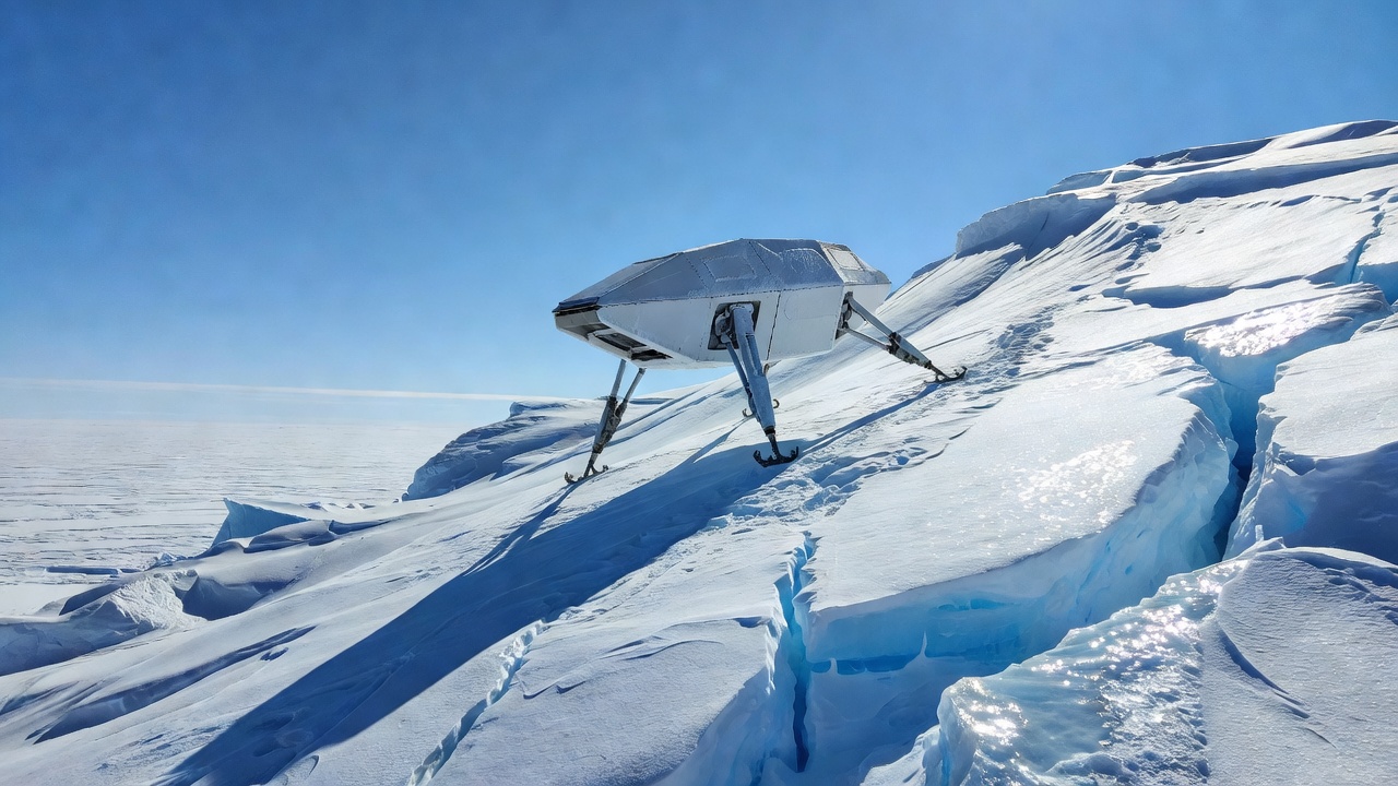 Extreme wide shot of Ice Dart resting on a sunlit iceberg slope, four X-shaped legs braced against 58-degree ice, bright blue sky, snow glare, wide-angle lens, crisp daylight clarity.